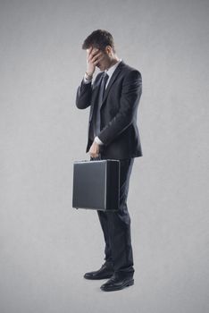 Frustrated young businessman covering his eyes.