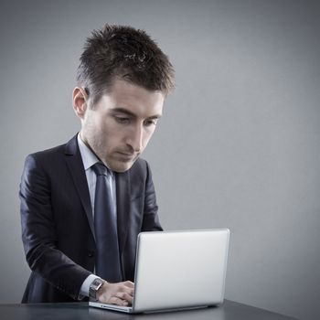 Talented businessman working at his laptop with big head full of ideas.