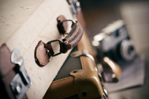 Vintage camera and old worn-out suitcase, travel concept.