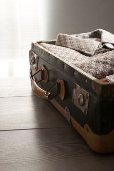 Open vintage suitcase with old fashioned clothes inside.