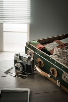 Traveler's suitcase with vintage equipment with camera and old pictures.
