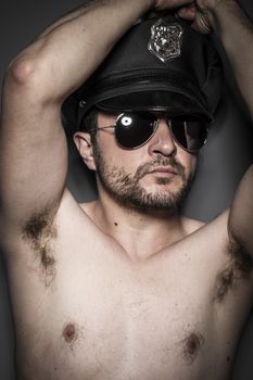 Nude, Good looking policeman, sexy police with sunglasses over dark background