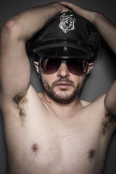 Good looking policeman, sexy police with sunglasses over dark background