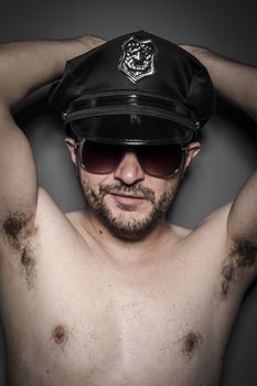 Good looking policeman, sexy police with sunglasses over dark background