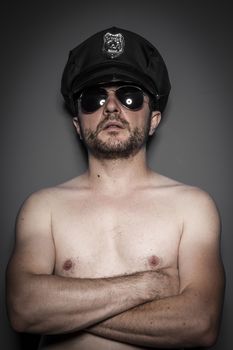 Sensual, Good looking policeman, sexy police with sunglasses over dark background