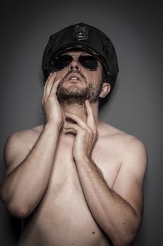 Strong, Good looking policeman, sexy police with sunglasses over dark background