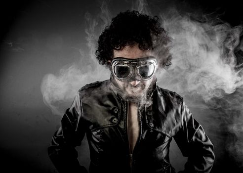 Male biker with sunglasses era dressed Leather jacket, huge smoke over dark background