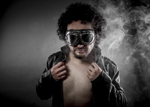 Sensual male biker with sunglasses era dressed Leather jacket, huge smoke over dark background