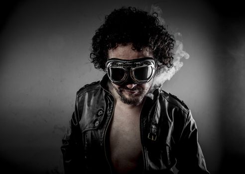 Sexy biker with sunglasses era dressed Leather jacket, huge smoke over dark background