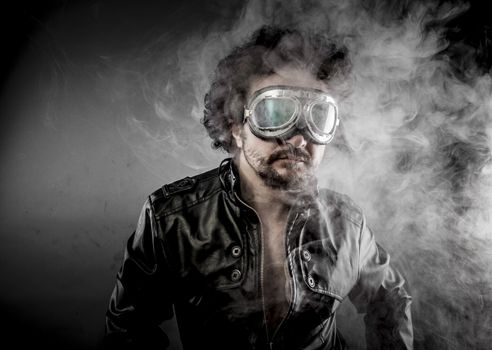 Motorcyclist, biker with sunglasses era dressed Leather jacket, huge smoke over dark background