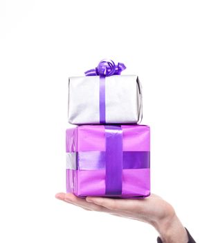 Male hand holds silver and purple gift over a white background. Birthday or Valentine day concept.