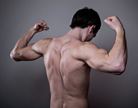 Muscular male back over dark background