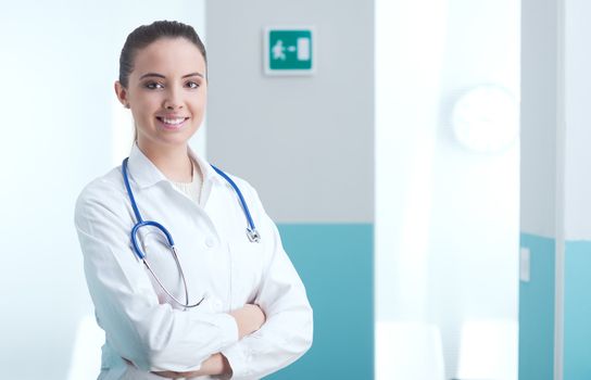 Portrait of a smiling female doctor standing with arms folded 