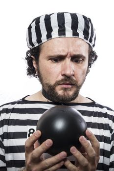 Funny man prisoner criminal with chain ball and handcuffs in studio isolated on white background