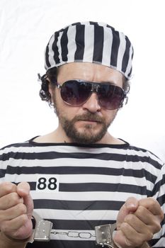 Locked, Desperate, portrait of a man prisoner in prison garb, over white background