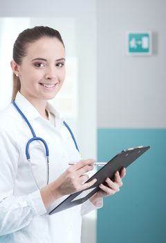 Young woman doctor or pharmacist in office with clipboard