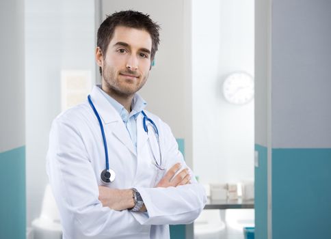 Young professional doctor at hospital with crossed arms