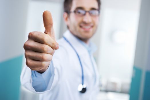 Young doctor expressing positivity and smiling with thumb up