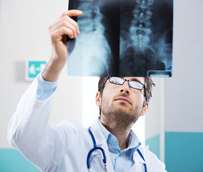 Professional radiologist examining an X-ray image of human spine.