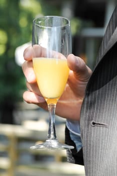 person in suit drinking orange juice and sparkling wine