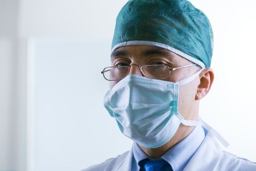 Senior professional surgeon with surgical mask and cap.