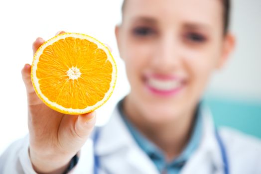 Happy female Nurse or Doctor holding an orange