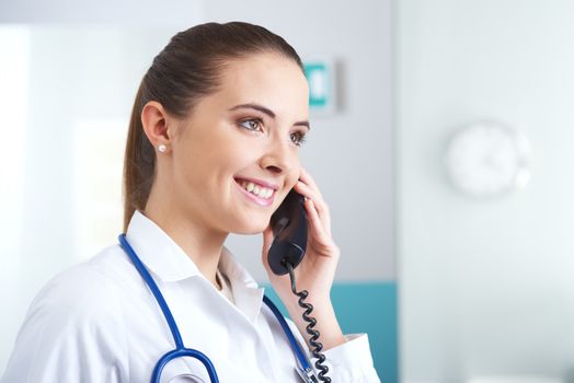 Young female doctor talking on the phone and smiling