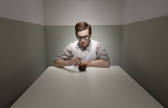 Geek guy having a coffee break in a small room.