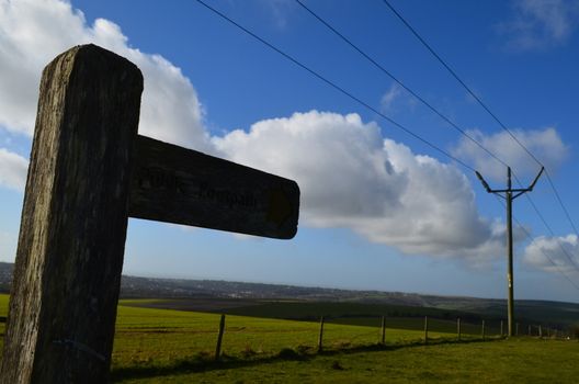 Traditional wood direction sign in the English countryside informing of a public footpath.