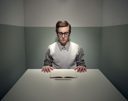 Geek funny guy with notebook in a small gray room.