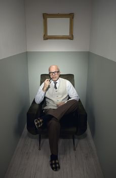 Senior handsome man relaxing in armchair with slippers.