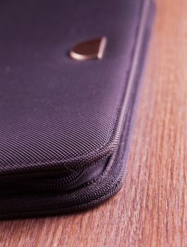 Elegant black folder over a wooden background