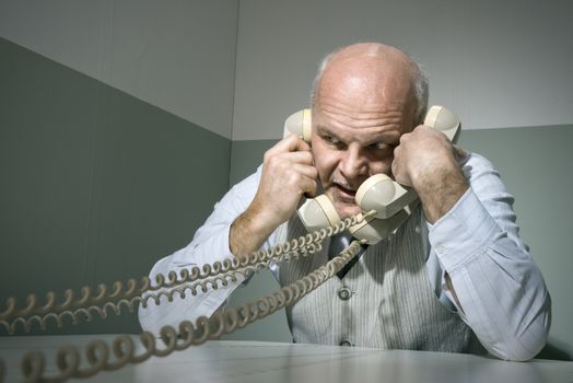 Stressed overworked businessman talking on the phone, vintage style.