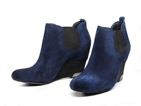 Blue suede woman's boots over white background