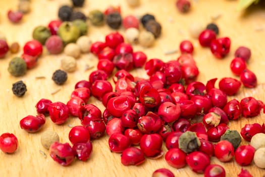 Dry multicolored peppercorn closeup on wooden background