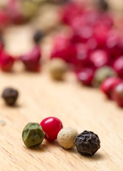 Dry multicolored peppercorn closeup on wooden background