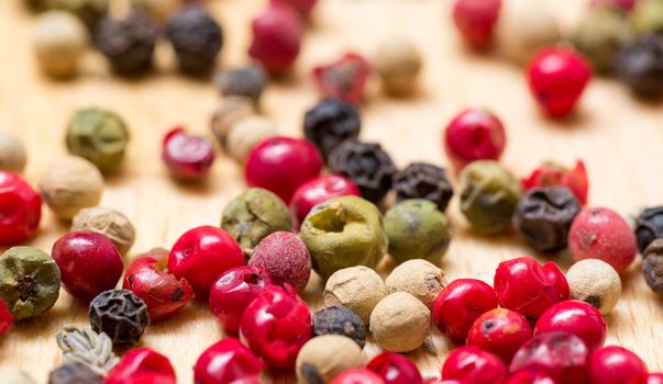 Dry multicolored peppercorn closeup on wooden background