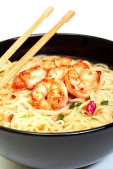 Shrimp and noodle soup bowl with chopsticks closeup