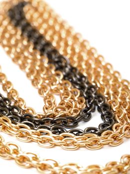Golden and black chains, closeup on the white background