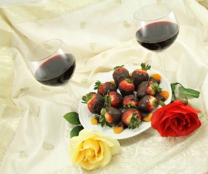Red wine with chocolate covered strawberries, chocolate covered apricots and rose