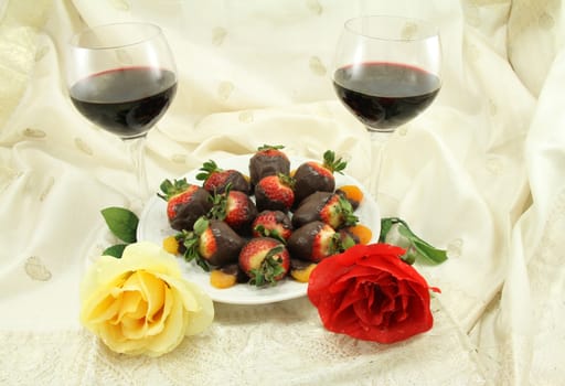 Red wine with chocolate covered strawberries, chocolate covered apricots and roses.