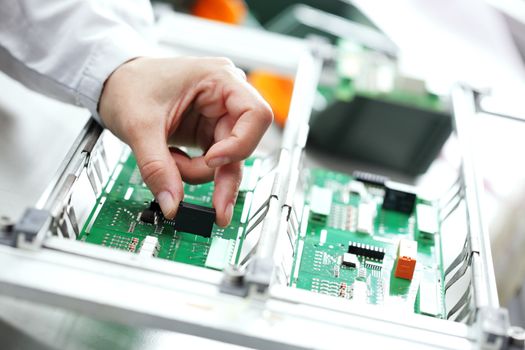 Technician assembling electonic components at his worktable.