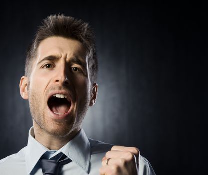 Excited young man shouting with raised fists.