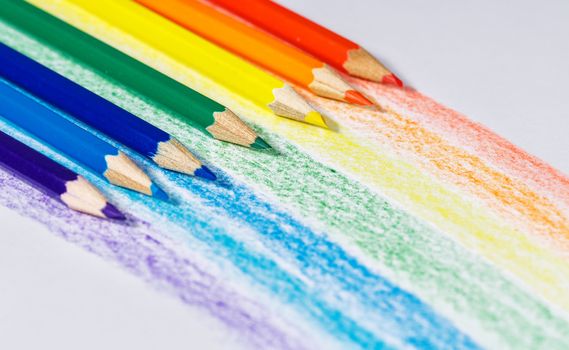 Rainbow colored pencils on textured paper shot close up