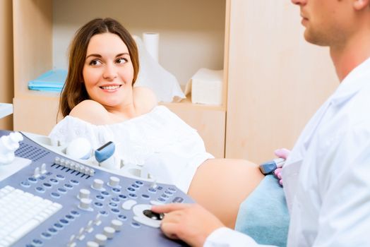 Young attractive pregnant woman on reception at the doctor, health check