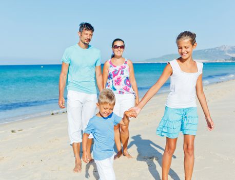 Family of four having fun on tropical beach