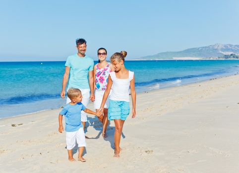 Family of four having fun on tropical beach