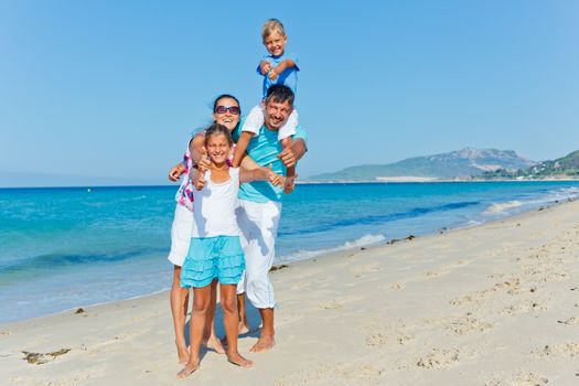 Family of four having fun on tropical beach