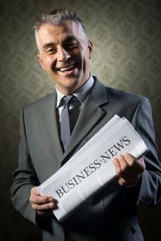 Handsome businessman holding newspaper against vintage wallpaper background.