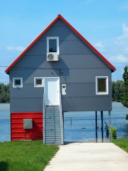 big flooded house with blue sky and white clouds in high water